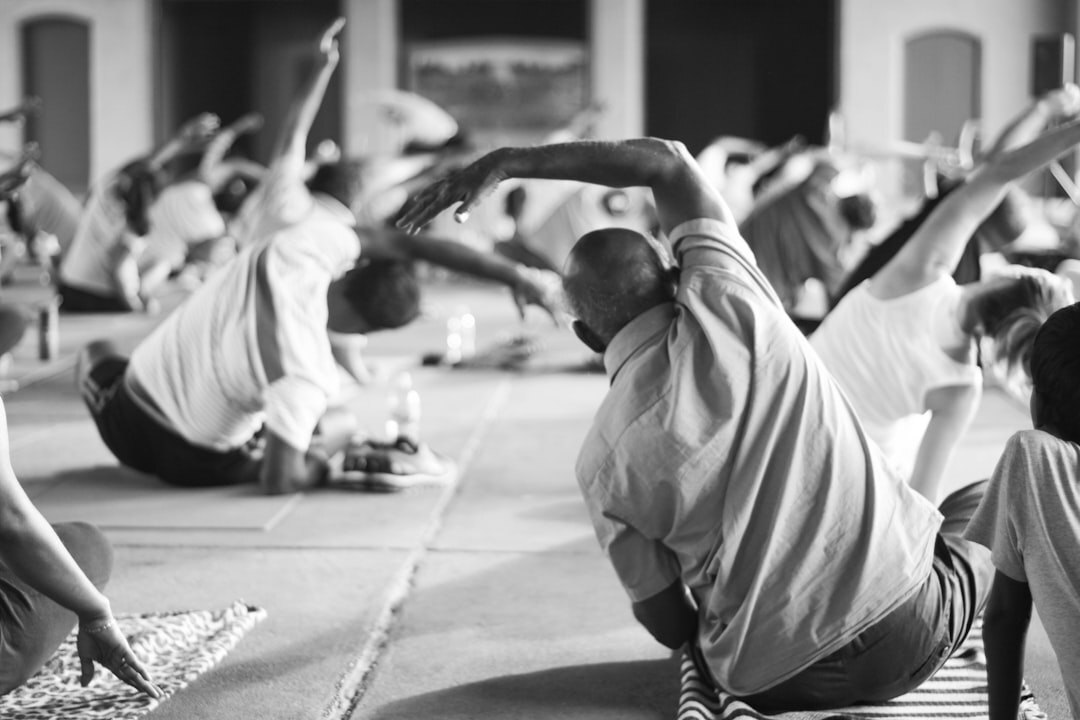 Seniors doing gentle yoga stretches in a sunny community hall