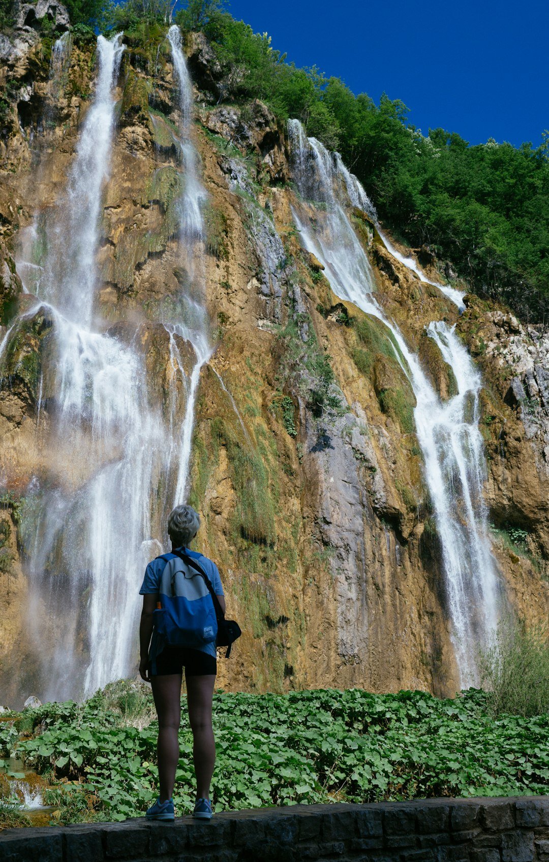 Seniors on a group day trip admiring Plitvice Lakes waterfalls