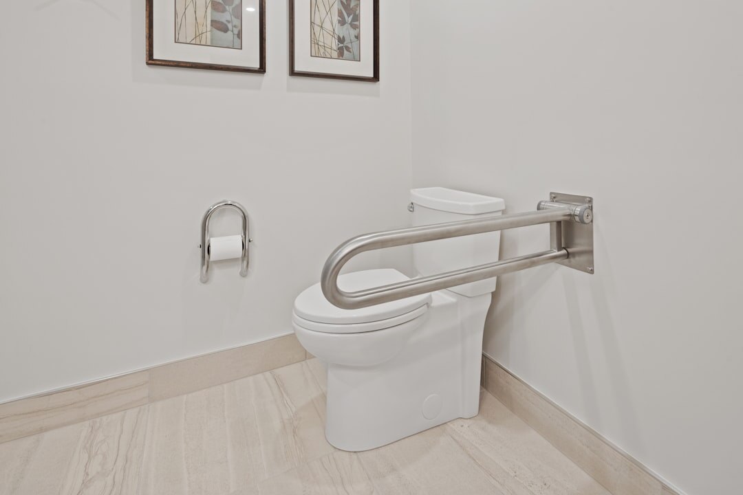 Senior man installing a handrail for home safety in a bathroom