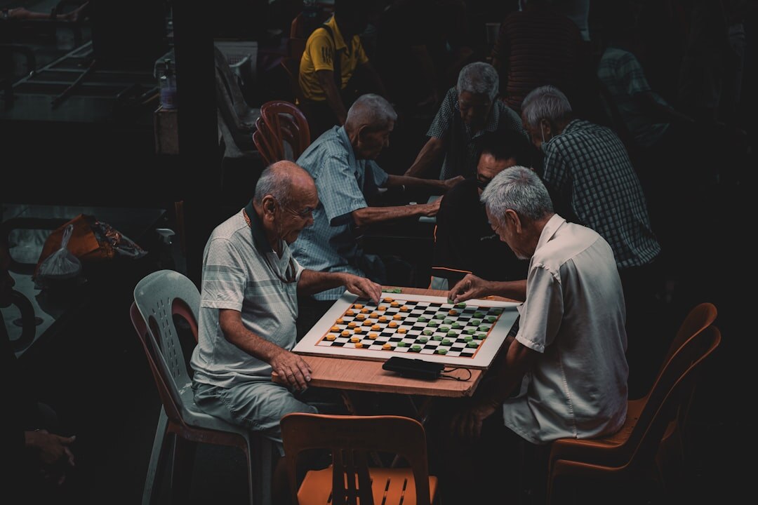 Two senior men playing chess at a club table